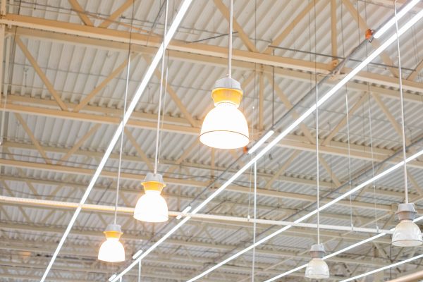 Ceiling with bright lamps in a modern warehouse. Image of bright light, a large space for trade, storage, commercial activity. large lighting lamps under the ceiling of the shopping center